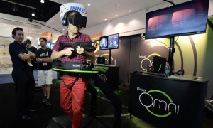 An attendee tries out the Virtuix Oculus Rift and Omni Treadmill game at the 2014 Electronic Entertainment Expo, known as E3, in Los Angeles