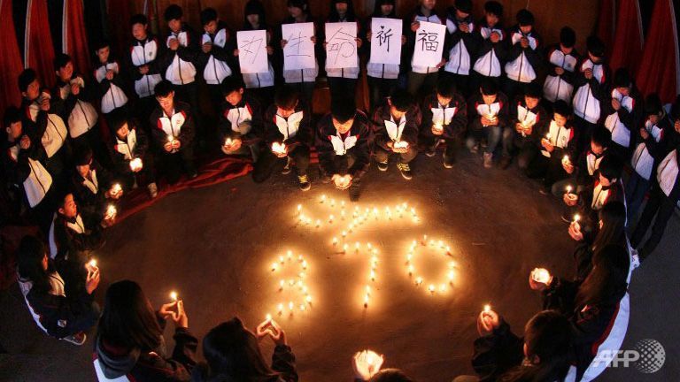 High school students hold candles during a vigil for passengers of the missing Malaysia Airlines flight MH370 in Lianyungang, east China's Jiangsu province. (AFP PHOTO)