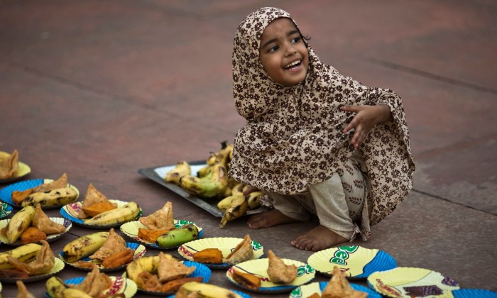 A girl arranges plates before iftar – the breaking-fast meal– during Ramadan at the Grand Mosque in Delhi, India. Photograph: Ahmad Masood/Reuters
