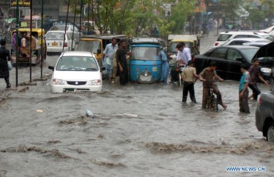 Vehicles move through a flooded street in southern Pakistan's Hyderabad on Sept. 9, 2012. (Xinhua/Janali)