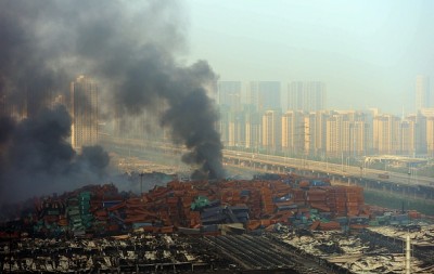 Fire and smoke rise at the site of the massive explosions in Tianjin on August 13, 2015. Enormous explosions in a major Chinese port city killed at least 44 people and injured more than 500, state media reported on August 13, leaving a devastated industrial landscape of incinerated cars, toppled shipping containers and burnt-out buildings. (Photo credit: STR/AFP/Getty Images)