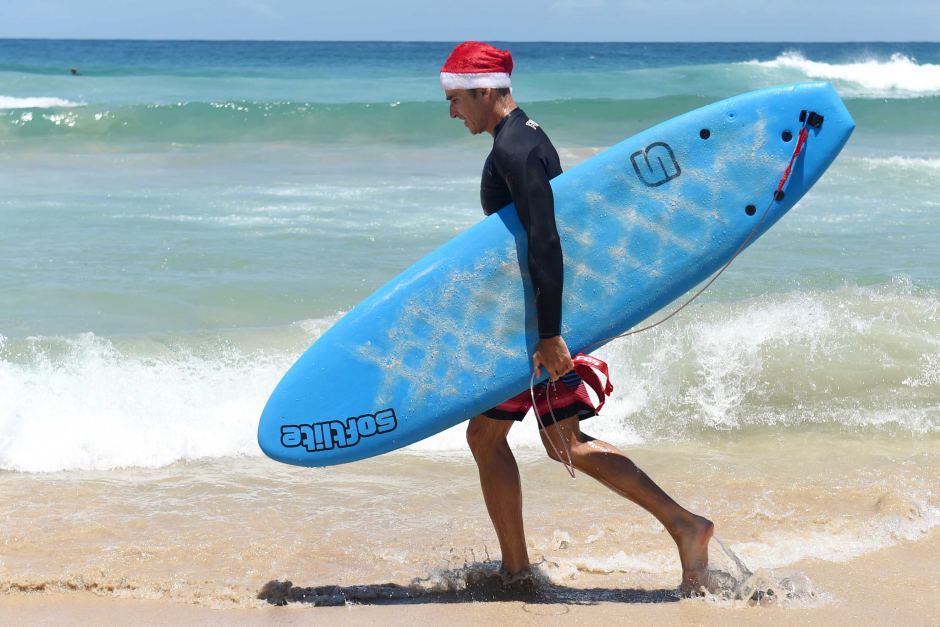 A surfer gets into the Christmas spirit at Bondi Beach. AAP: Paul Miller
