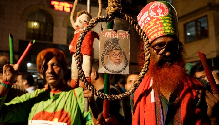 Demonstrators hold a photo of Motiur Rahman Nizami, in front of Dhaka central jail before his execution. Photograph: Abir Abdullah/EPA