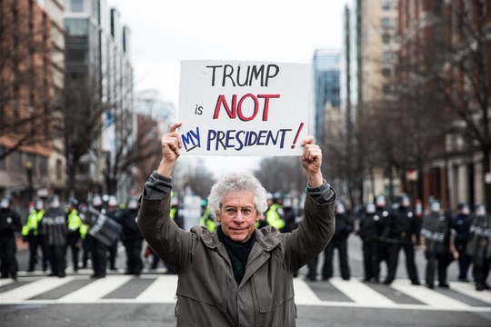A protestor marches in front of riot policeat the inauguration of Donald Trump on January 20, 2017 in Washington, D.C.