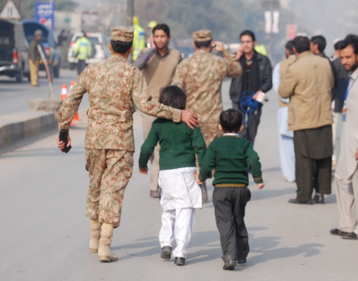 A soldier escorts schoolchildren after they were rescued from the Army Public School that is under attack by Taliban gunmen in Peshawar Reuters Photo: Khuram Parvez