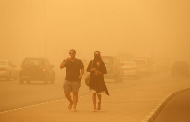 A woman walks with her face covered during a sand storm in Dubai April 2, 2015.  Photo: REUTERS/Ahmed Jadallah