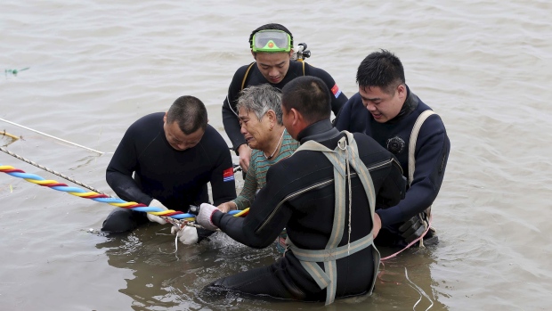 Divers pulle a 65-year-old woman from the hull of the passenger ship carrying 458 people that capsized on China's Yangtze River on Tuesday morning. (CNS photo via Reuters)