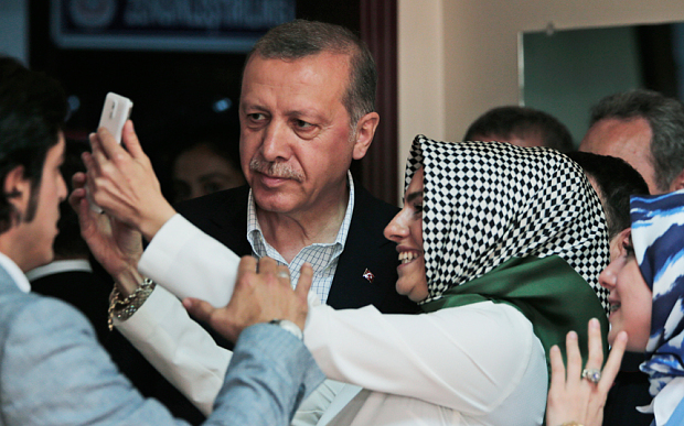 Recep Tayyip Erdogan poses for a selfie with a woman after voting at a polling station in Istanbul Photo: Lefteris Pitarakis/AP