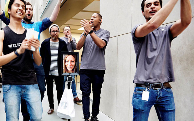 The face of Australian woman Lucy Kelly appearing on an iPad attached to a Segway-style device as she became one of the first people to buy one of the latest iPhones at the Apple store in Sydney. Photo: AFP