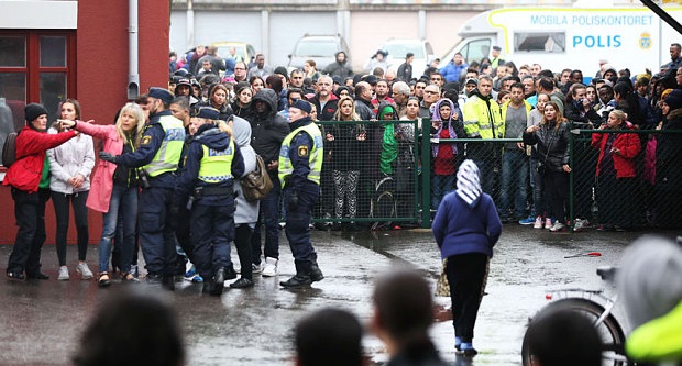 Swedish police officers speak to members of the public as they secure the area outside the school Photo: AFP/Getty Images