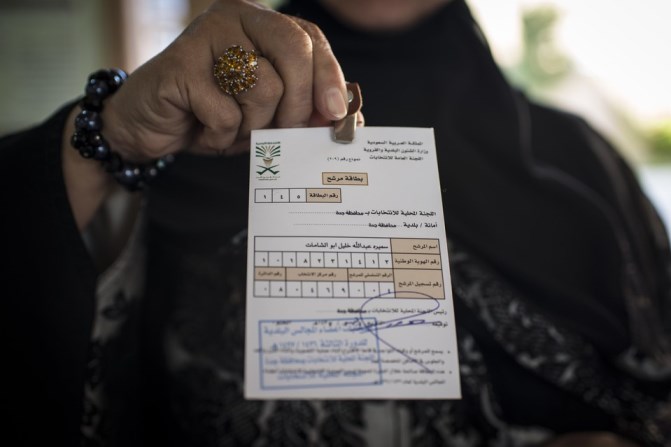 A woman holds up her election card, which is No. 1, indicating that she was the first to sign up at voting registration at a girls high school in North Jeddah on Saturday.