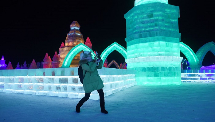 A woman uses a mobile phone to take a picture at the China Ice and Snow World on the eve of the opening ceremony of the Harbin International Ice and Snow Festival in Harbin, northeast China's Heilongjiang province on January 4, 2016. Over one million visitors are expected to attend the spectacular Harbin Ice Festival, where buildings of ice are bathed in ethereal lights and international ice sculptors compete for honours. AFP PHOTO / WANG ZHAOWANG ZHAO/AFP/Getty Images ORG XMIT: