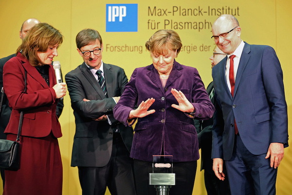 German chancellor Angela Merkel prepares to press the start bottom next to the head of the Max Planck Institute for Plasma Physics Sibylle Guenter, left, and Mecklenburg-Western Pomerania governor, Erwin Sellering, right at the Wendelstein 7-X' nuclear fusion research center at the Max-Planck-Institut for Plasma Physics in Greifswald, Germany Wednesday Feb. 3, 2016. (Bernd Wuestneck/AP)