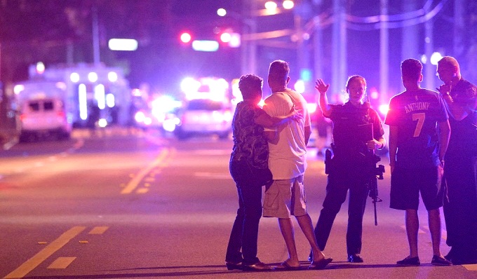 Police direct relatives away from the scene of a mass shooting at a gay nightclub in Orlando, Fla., early Sunday. (AP Photo/Phelan M. Ebenhack)