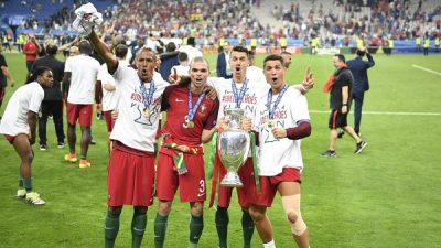 Portugal's forward Eder (L), Portugal's defender Pepe, Portugal's defender Fonte pose with Portugal's forward Cristiano Ronaldo (R) as he holds the winners' trophy after beating France 1-0 in the Euro 2016 final football match between France and Portugal at the Stade de France in Saint-Denis, north of Paris, on July 10, 2016. / AFP / MARTIN BUREAU (Photo credit should read MARTIN BUREAU/AFP/Getty Images)