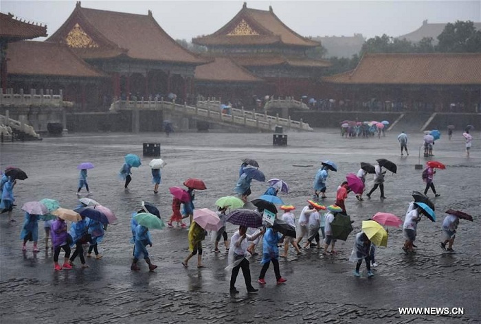 Tourists visit the Forbidden City in rain in Beijing, capital of China, July 20, 2016. Beijing's meteorological bureau issued an orange alert for rainstorm Wednesday noon. Photo: Xinhua/Luo Xiaoguang