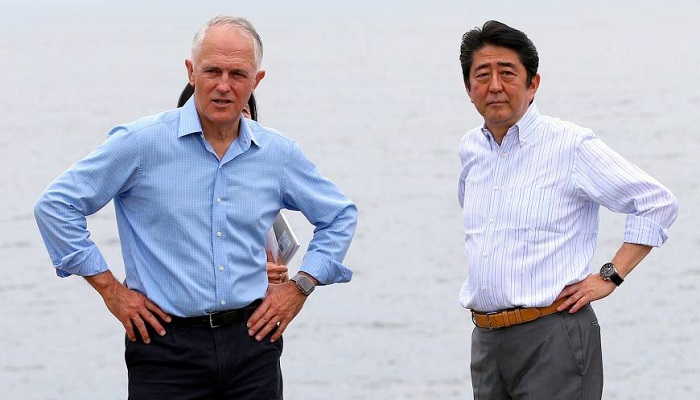 Prime Minister Shinzo Abe and Australian leader Malcolm Turnbull walk together along the shore of Sydney Harbor on Saturday. Photo: REUTERS